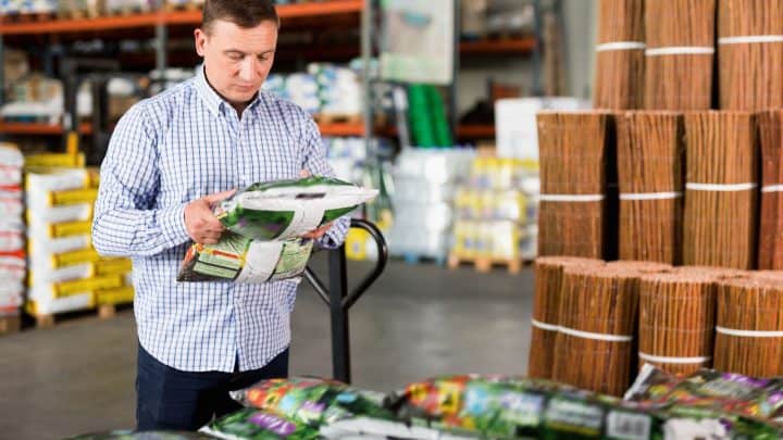 Man reading a fertilizer bag label