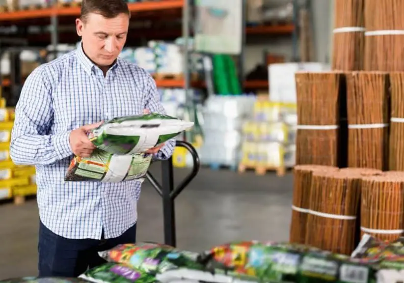 Man reading a fertilizer bag label