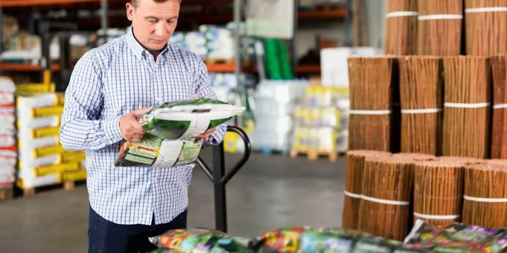 Man reading a fertilizer bag label